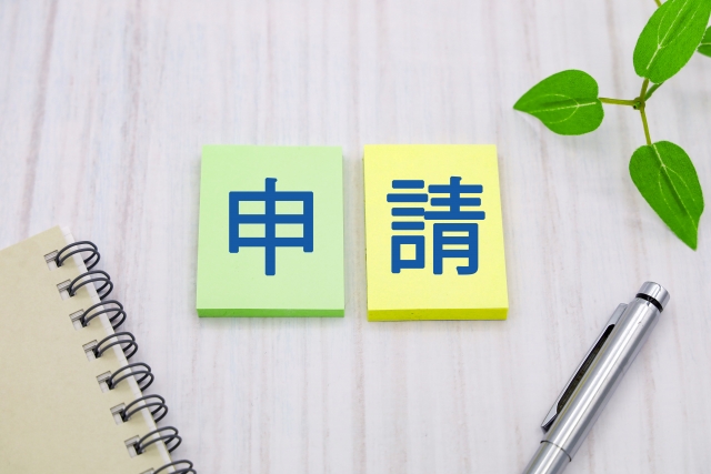 申請書類とペンと植物の配置