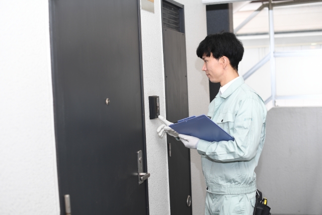 作業服の男性がドアをチェックする