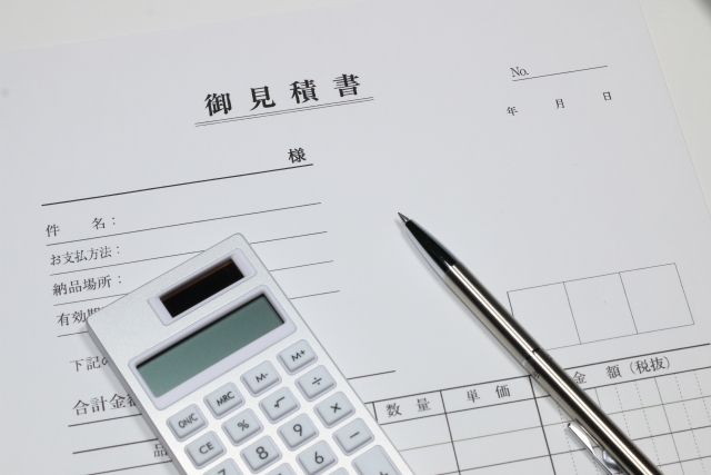 見積書とペンと電卓が机の上