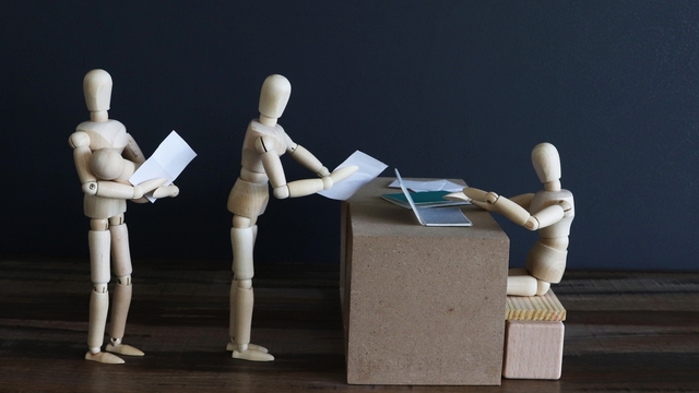 木製人形が机で会議の様子